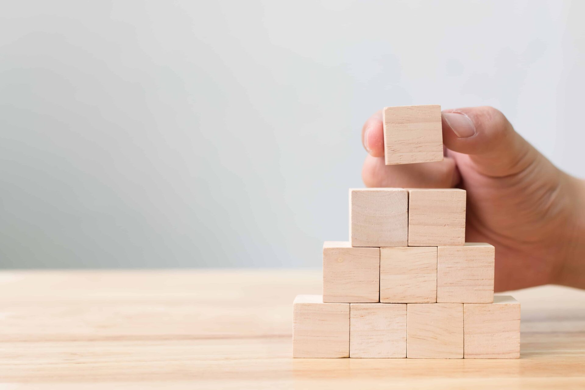 person stacking small wooden blocks