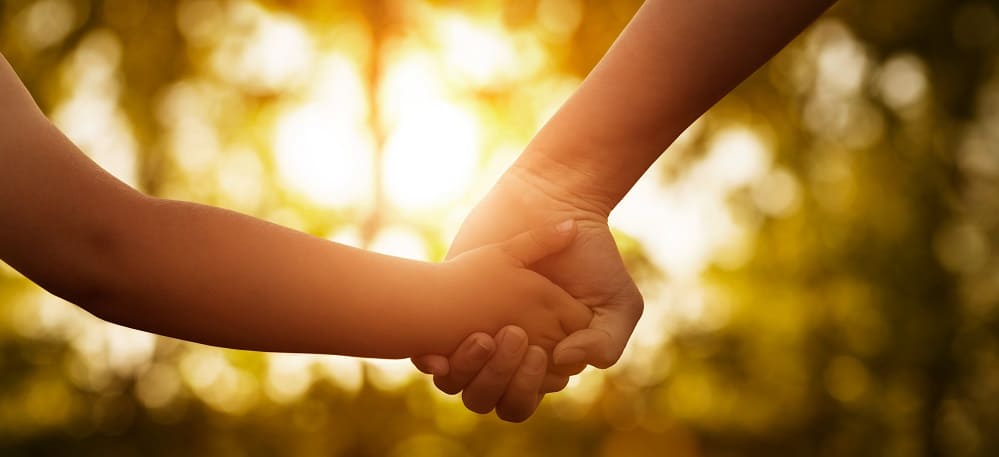 young person and old person holding hands