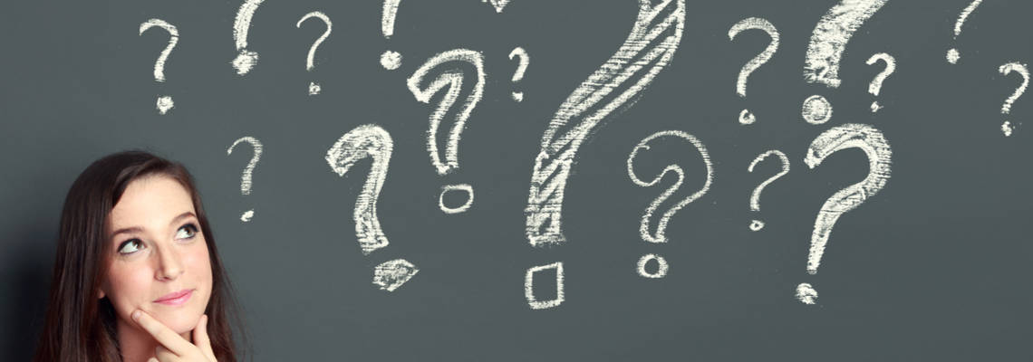 woman thinking with question marks on chalkboard