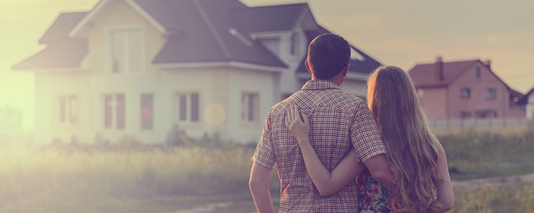 young couple looking out at new house
